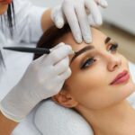 Beautician Doing Permanent Eyebrows Makeup Tattoo On Woman Face